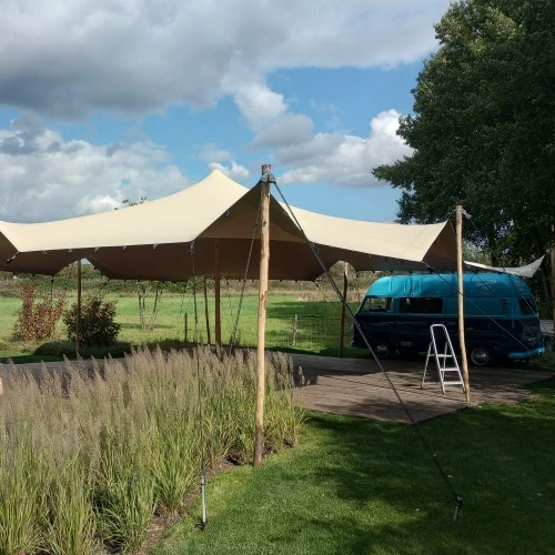 Stretchtent in tuin naast camper