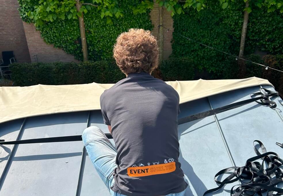 Teamlid monteert tentdak