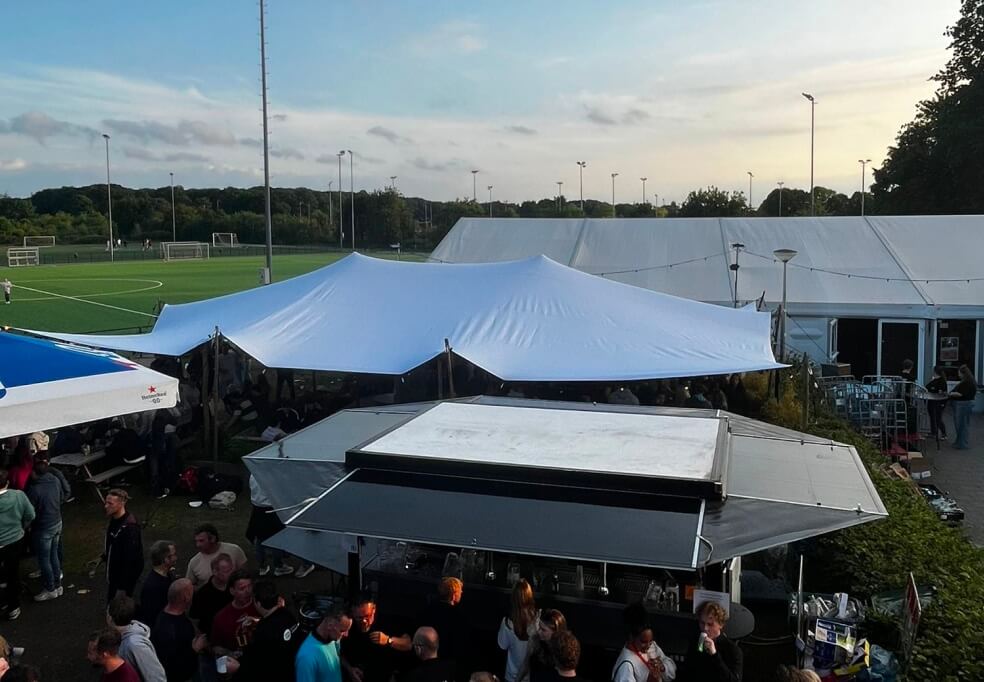 Stretchtent met buitenbar bij sportveld